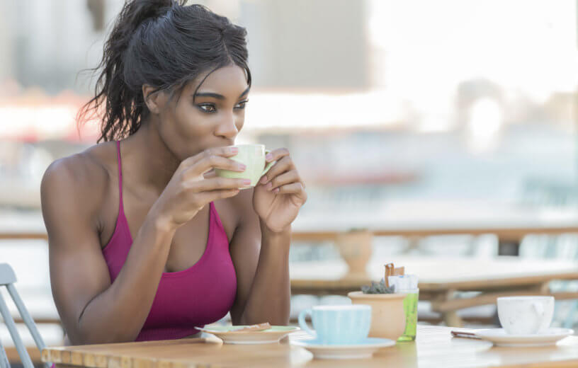 Athletic woman drinking coffee before exercise or workout