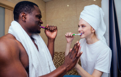 Couple sharing bathroom, brushing teeth together