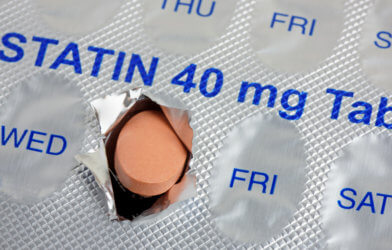 A statin tablet emerging from a marked weekly blister pack