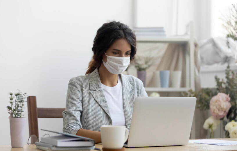 Woman wearing face mask while working during coronavirus outbreak
