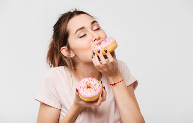 Woman eating doughnuts, junk food