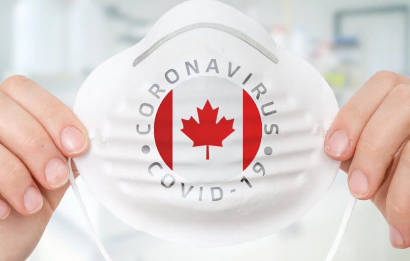 Person holding mask with Canadian flag for coronavirus / covid-19