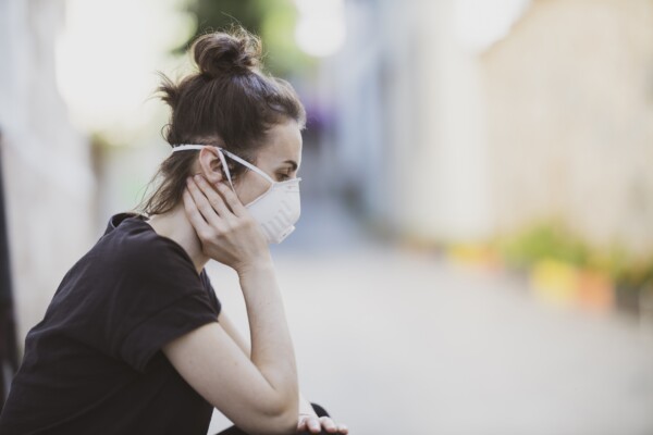 Loneliness during coronavirus outbreak: woman in mask feeling sad