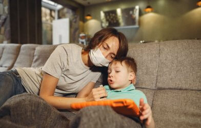 Mother wearing mask while playing with young son