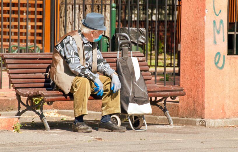 Man sitting on bench with mask, gloves during coronavirus / COVID-19 outbreak
