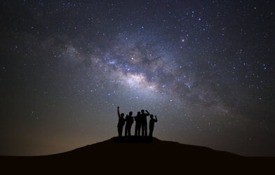 People looking up at Milky Way galaxy in night sky