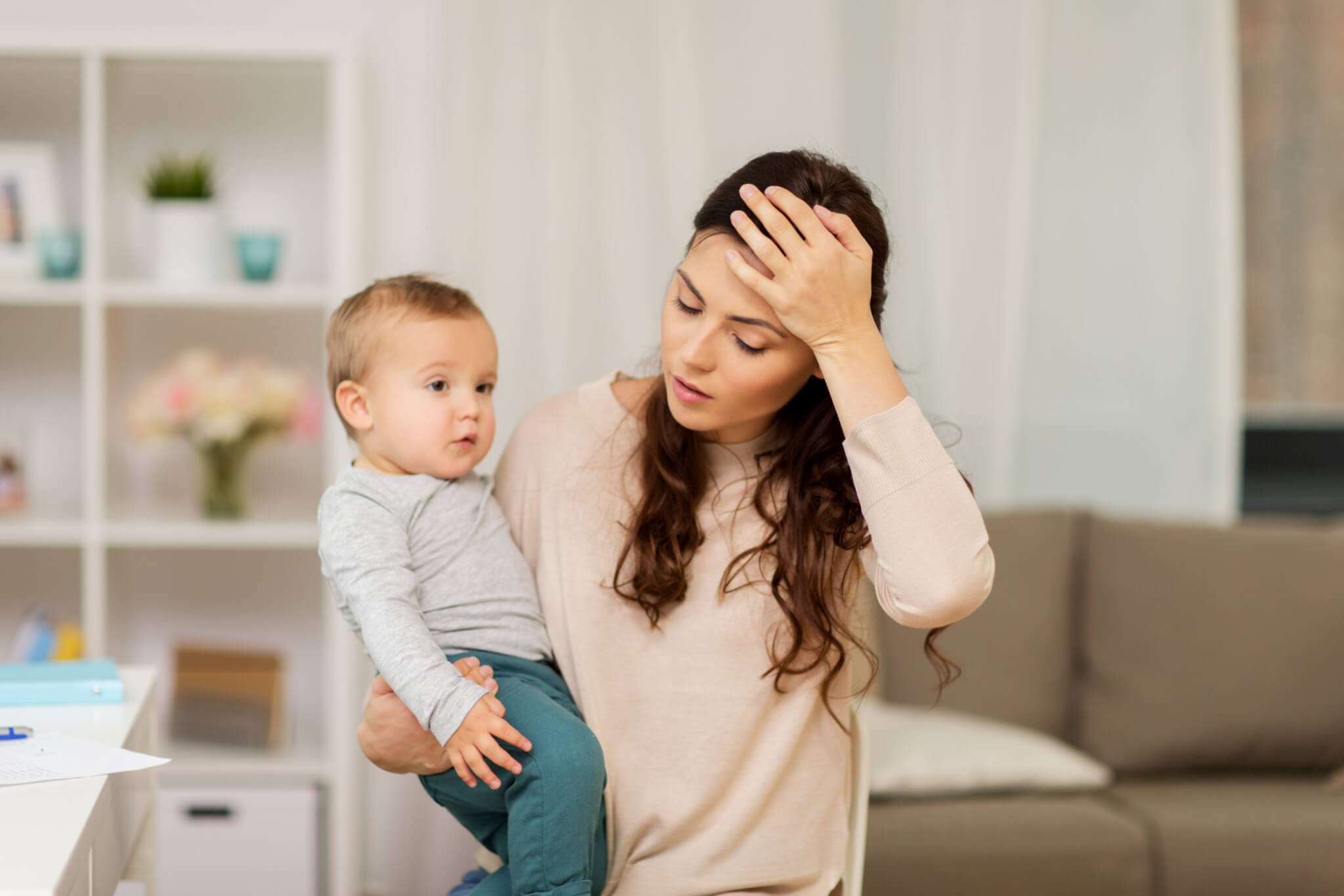 Exhausted, stressed mother with baby sighing