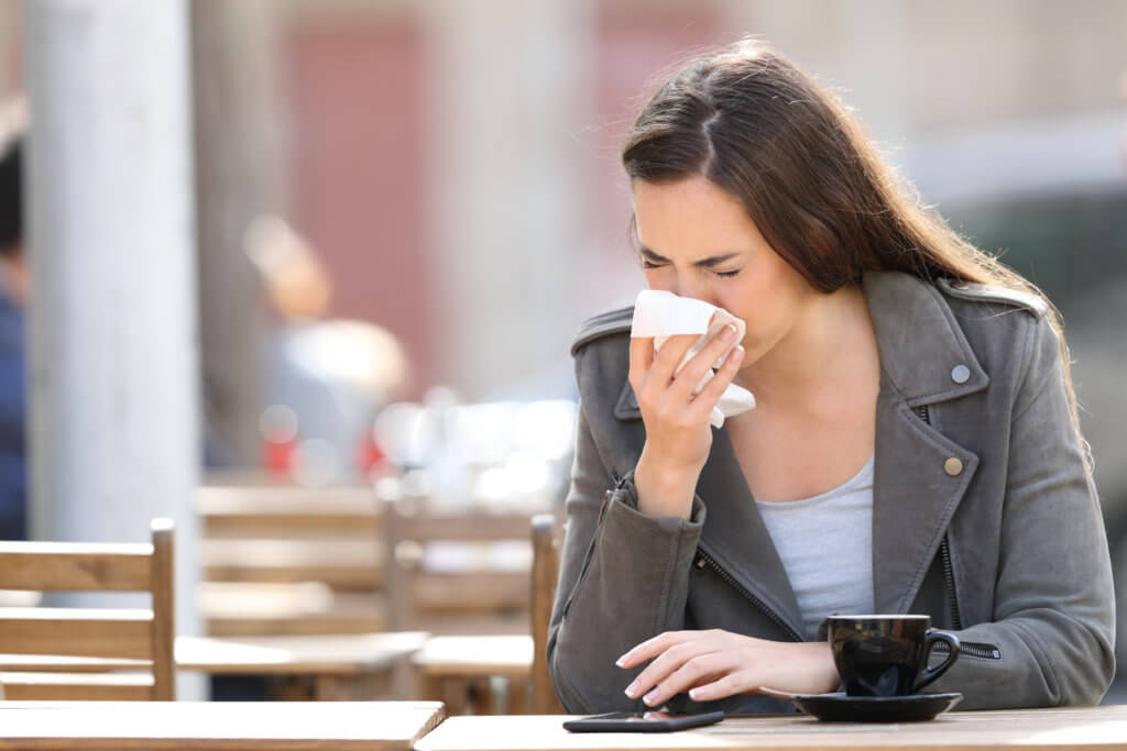 Sick woman blowing her nose, sneezing