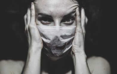 Woman in mask stressed during COVID-19 / coronavirus pandemic
