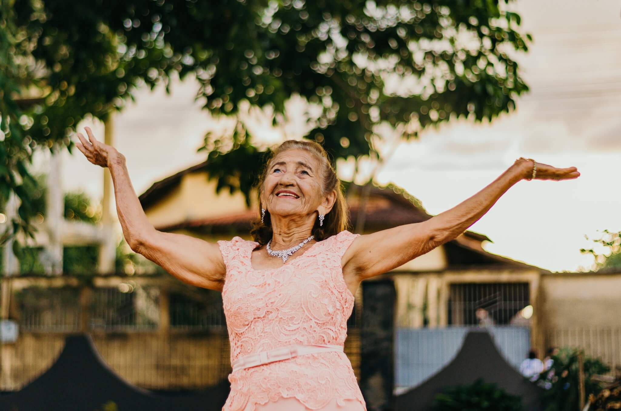 Long, happy life: Elderly woman with hands in the air