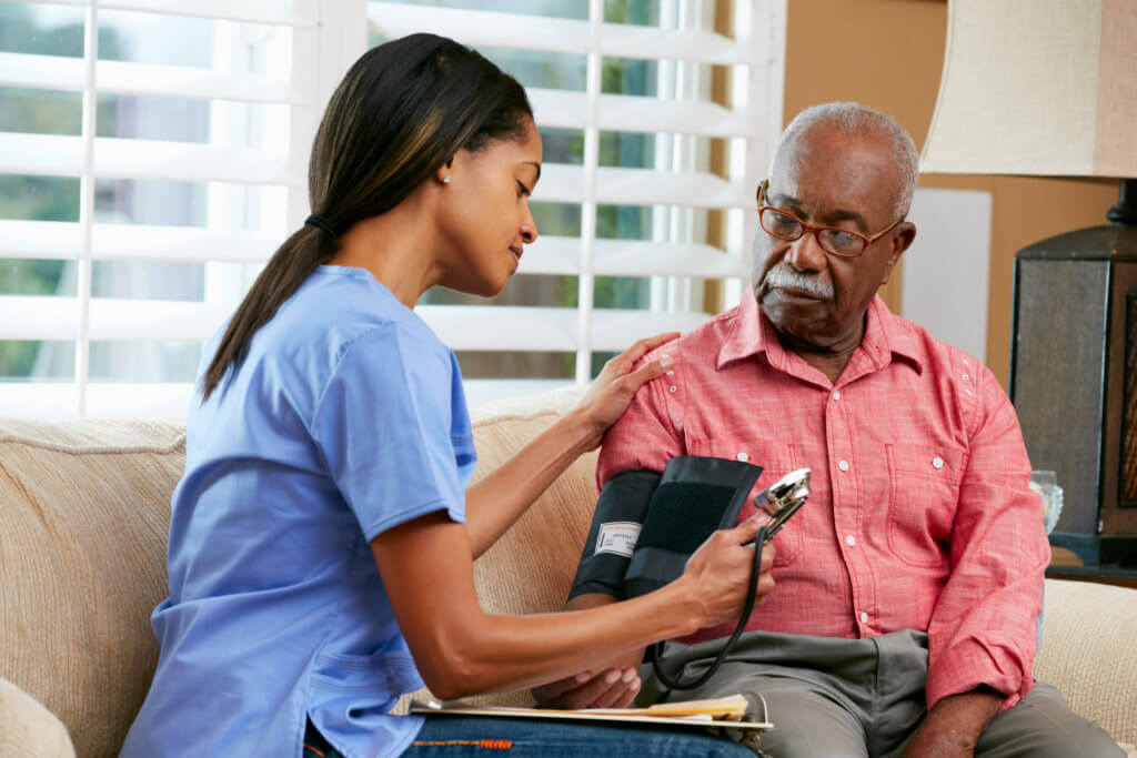 Nurse measuring older African American man's blood pressure