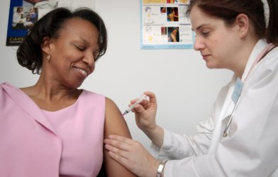 Doctor giving woman vaccination shot