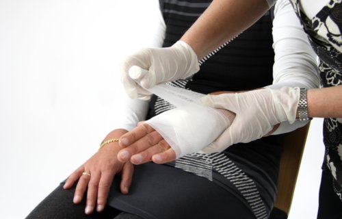 Woman having wound or injury bandaged up