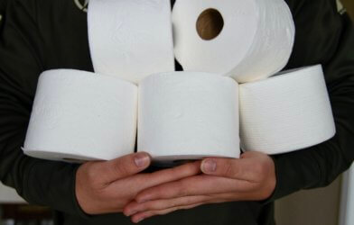 Person holding toilet paper stockpile