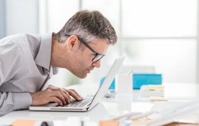 Man battling vision problems, macular degeneration effects while looking at computer