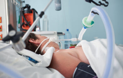 Intubated woman with ventilator assisted breathing due to flu or coronavirus pneumonia