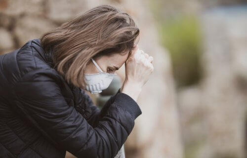 Sad, stressed woman wearing face mask during coronavirus outbreak