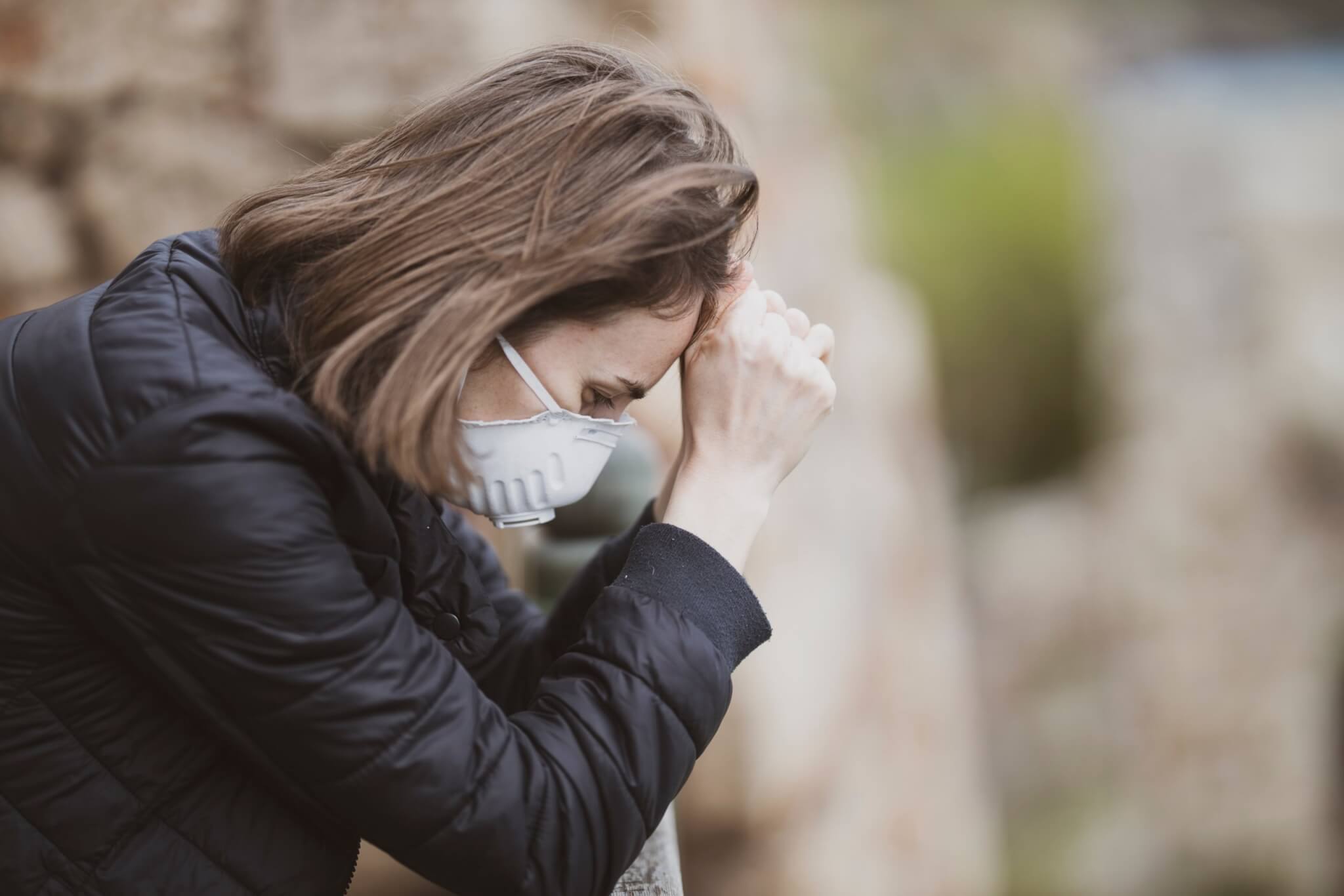 Sad, stressed woman wearing face mask during coronavirus outbreak