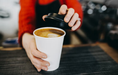 Barista holding coffee in paper cup