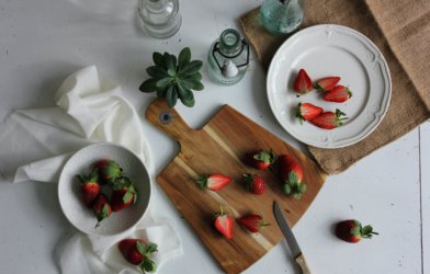 Plate of sliced strawberries on table with tablecloth