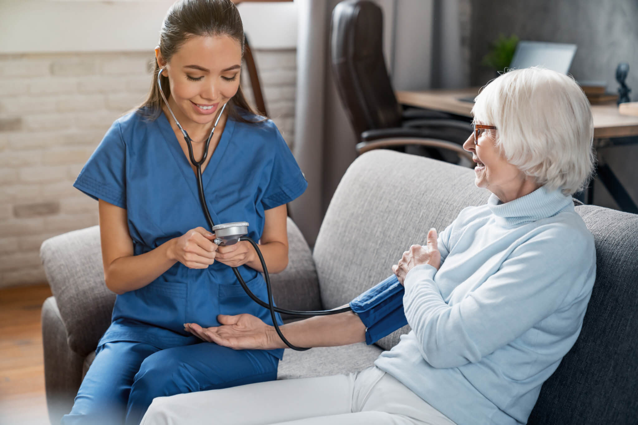 Nurse takes elderly patient's blood pressure