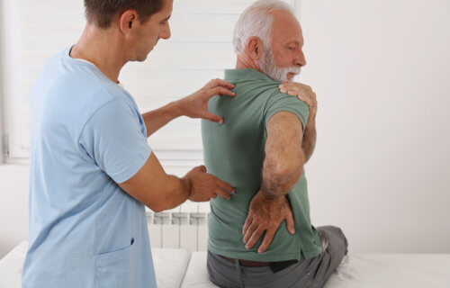 Older man battling shoulder pain, back pain, arthritis