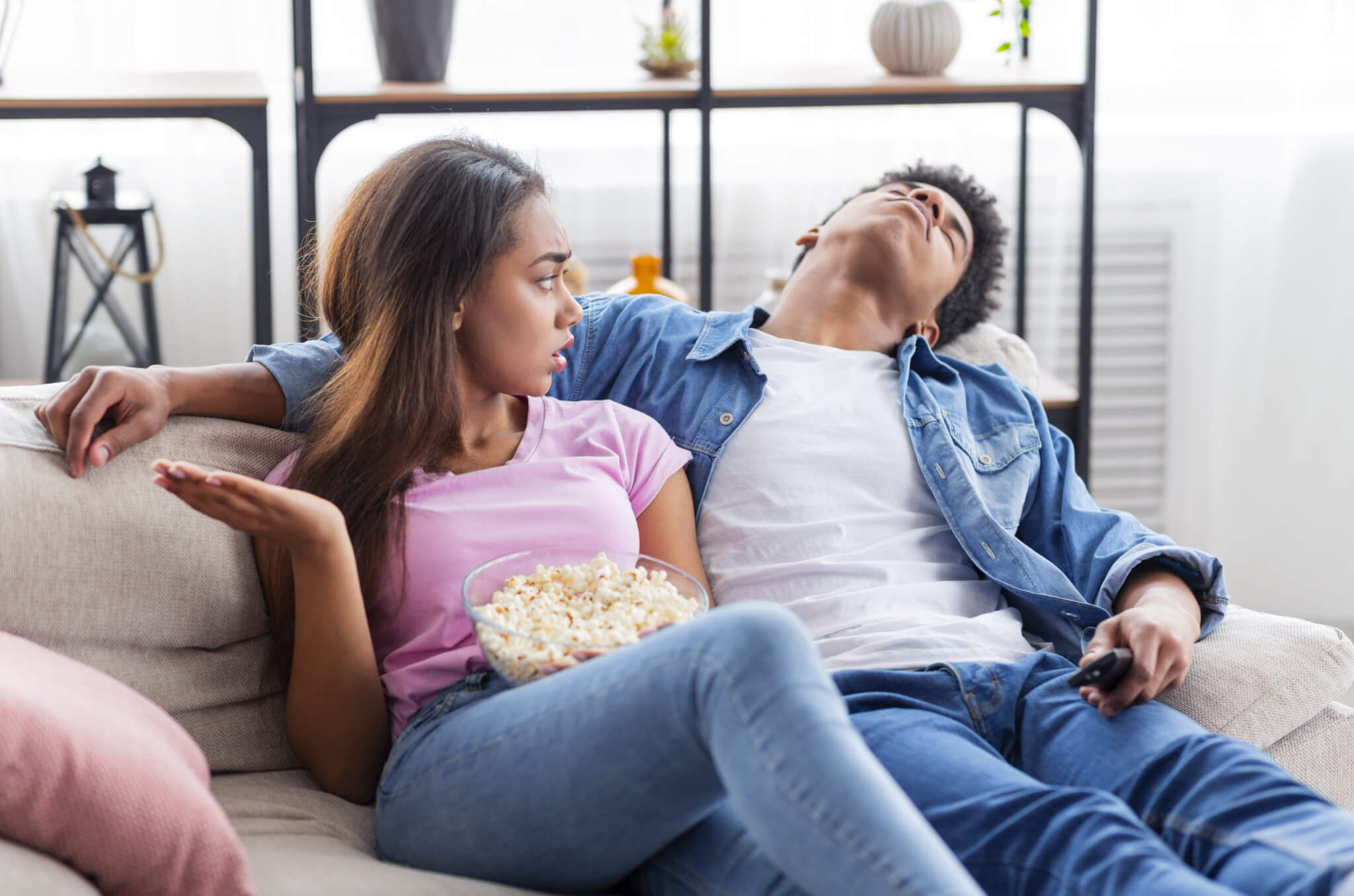 Girlfriend or wife upset with bored partner watching a movie