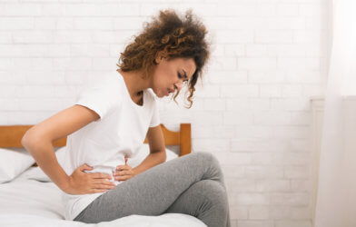 Woman in bed with stomach pain, cramps