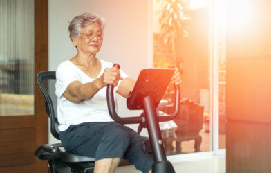 Older senior women using exercise bike