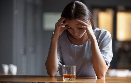 Woman drinking alcohol alone, stressed, depressed