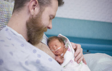Dad holding baby at hospital
