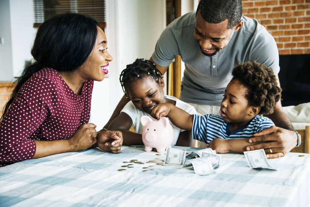 Family putting savings in piggy bank