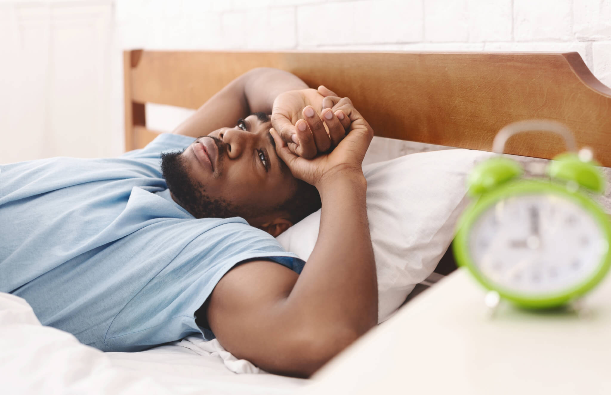 Man awake in bed, can't sleep from insomnia or sleep apnea