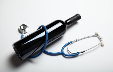 Alcohol and wine: Bottle of wine wrapped in stethoscope