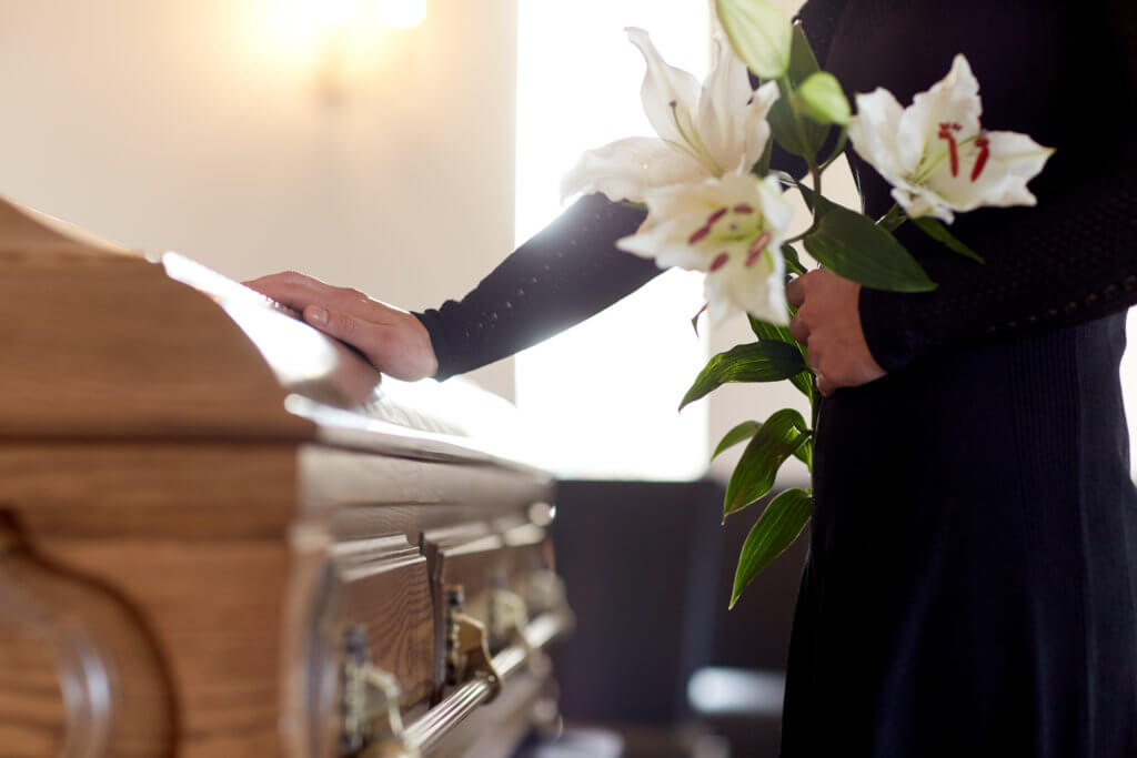A mourner touches the coffin at the funeral