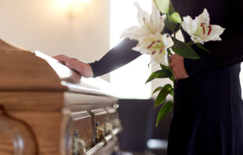 Mourner touching casket at funeral