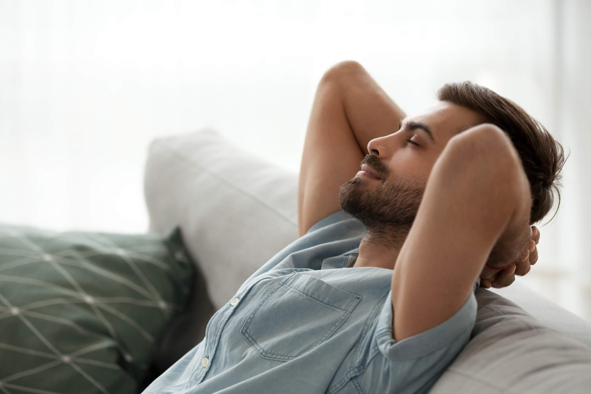 Man relaxing on couch alone, resting, happy