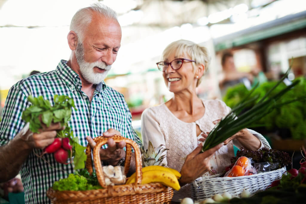 Older couple shopping for healthy food, fruits and vegetables