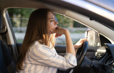 Woman driving car, tired, thinking, traffic jam