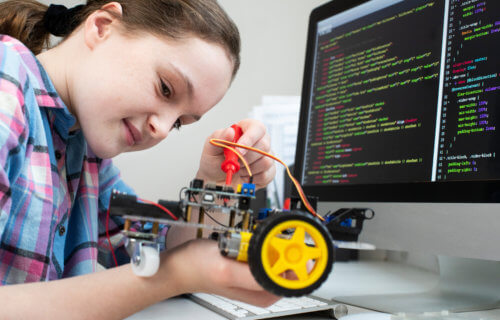 Young girl building robot, computer science or STEM class