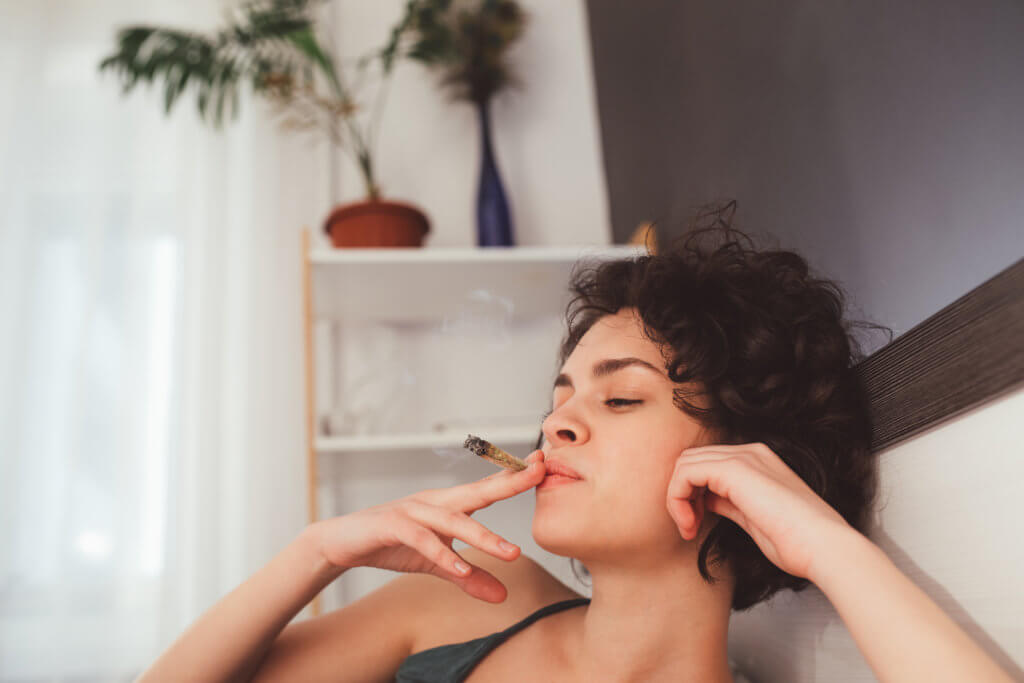 Woman smoking marijuana in bed