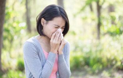 Woman sneezing from allergies, cold