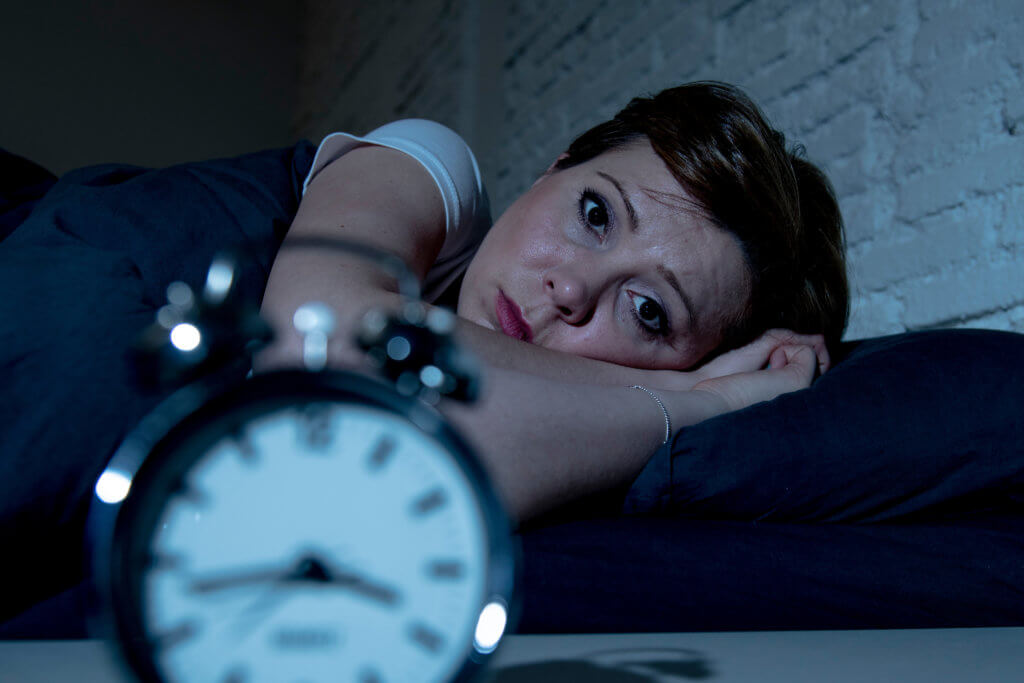Woman awake in bed from insomnia, can't sleep
