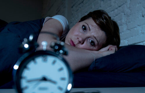 Woman awake in bed from insomnia, can't sleep