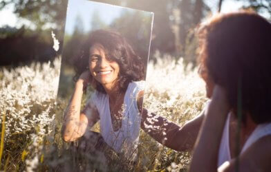 Woman looking in mirror smiling