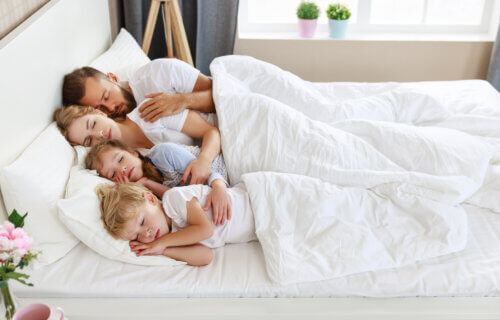 Parents and children sleeping, co-sharing bed