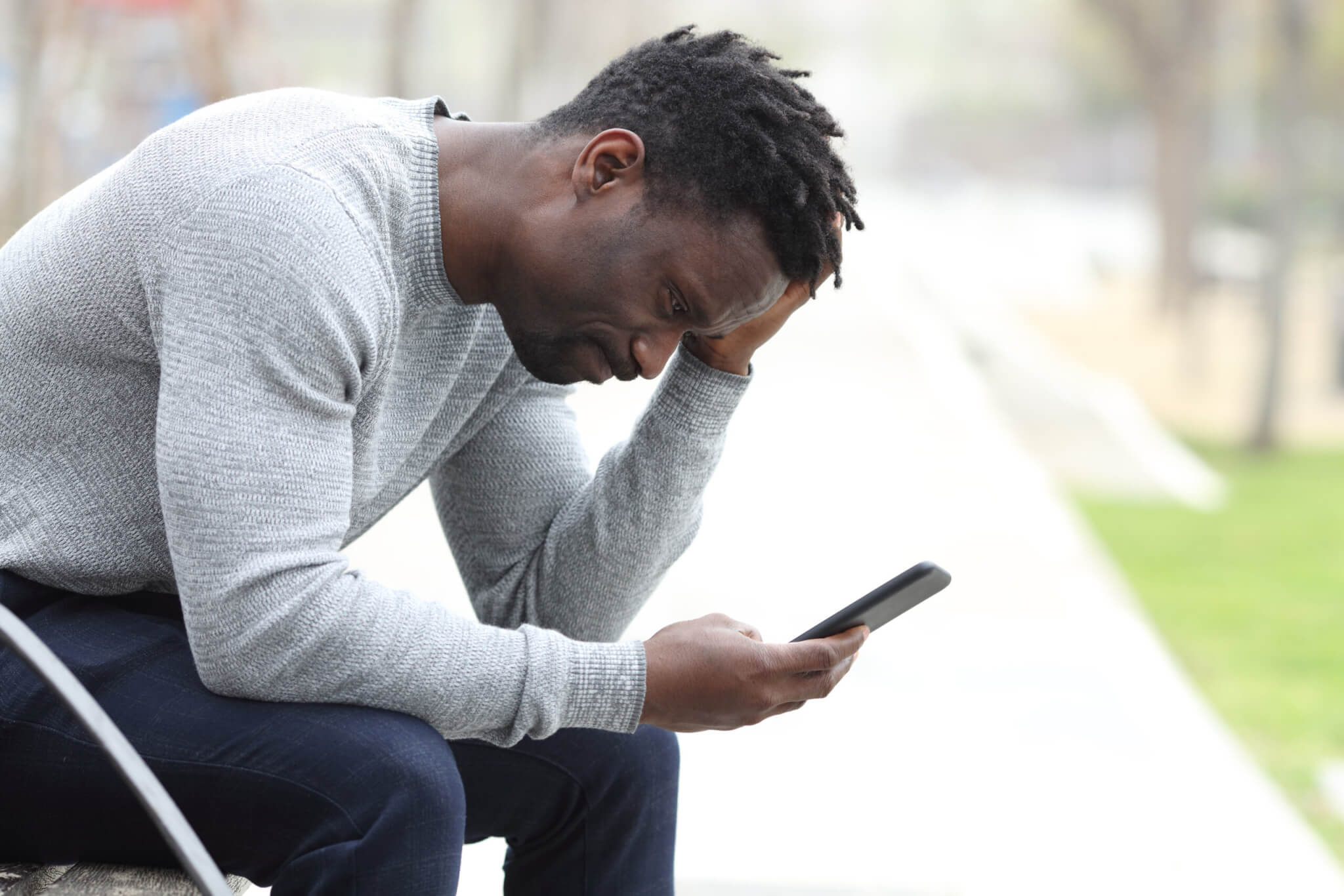 Sad, stressed man checking smartphone