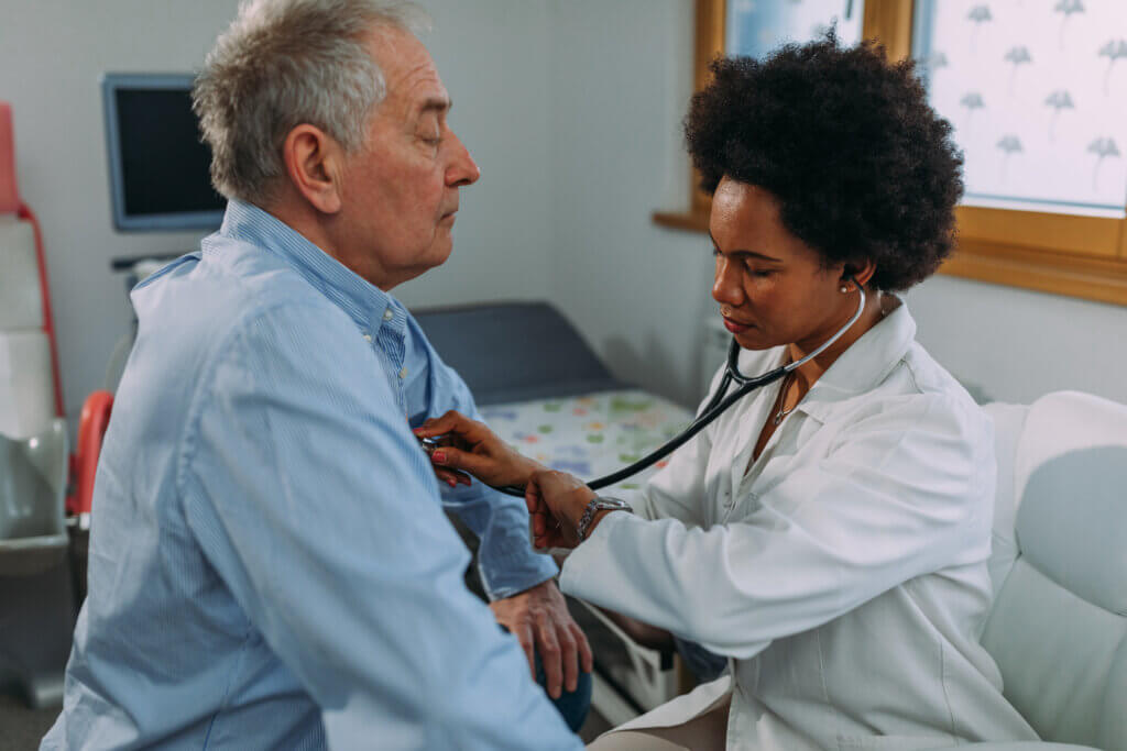 Le docteur examine un vieil homme, écoute son coeur avec un stéthoscope
