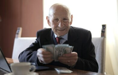 Older man in business suit looking at money