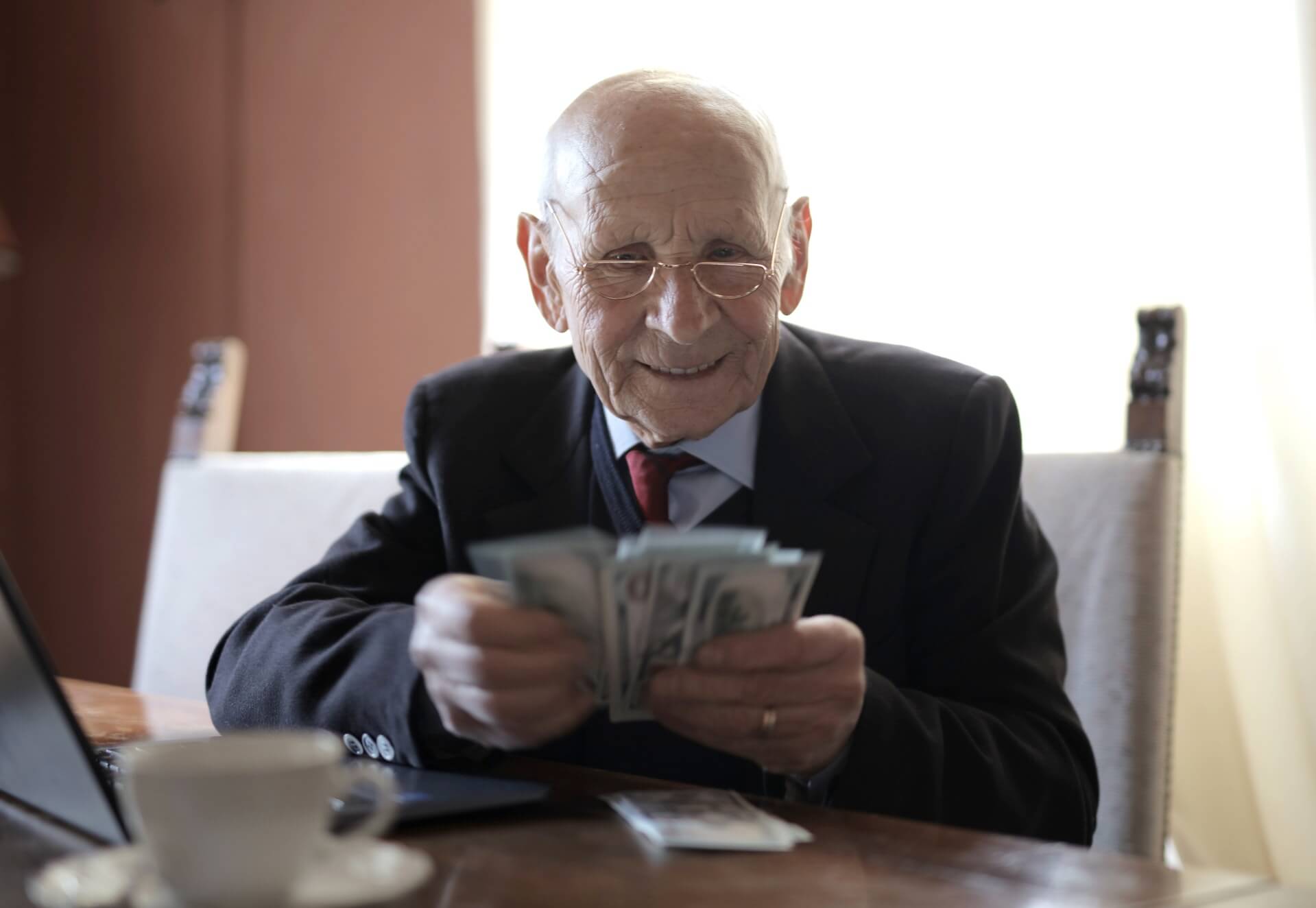 Older man in business suit looking at money